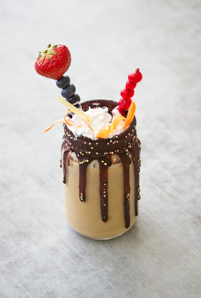 Indulge in a refreshing chocolate smoothie topped with vibrant berries and sprinkles.