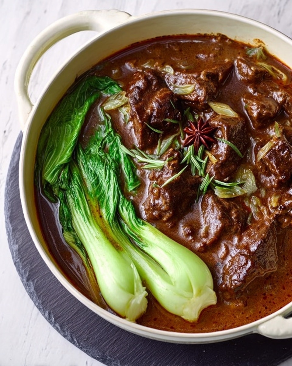 A white round pot contains a rich brown stew with visible large chunks of tender meat and pieces of onion and herbs floating in the thick sauce. On one side inside the pot, there are three bright green, fresh-looking bok choy stems nestled in the sauce, adding a fresh contrast to the brown stew. A single star anise is also floating among the meat pieces, adding texture and interest. The pot is placed on a dark round mat on a white marbled surface, creating a clean, simple setting. Photo taken with an iphone --ar 4:5 --v 7