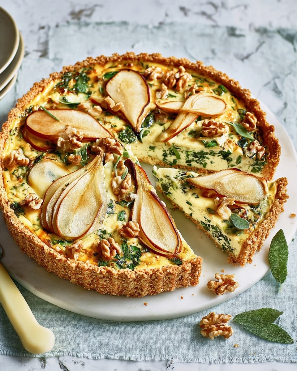 The image shows a round savory tart with a golden-brown crumbly crust that forms the base layer. The tart is filled with a creamy, pale yellow cheese and egg mixture speckled with green leafy herbs evenly spread throughout. On top, there are thin slices of baked pear with a light brown edge, scattered walnut halves with a rough texture, and a few fresh green sage leaves placed both flat and upright. One slice has been cut and slightly pulled out from the tart. The tart rests on a round white plate, which sits on a white marbled textured surface. A knife with a pale yellow handle is placed next to the tart. Photo taken with an iphone --ar 4:5 --v 7