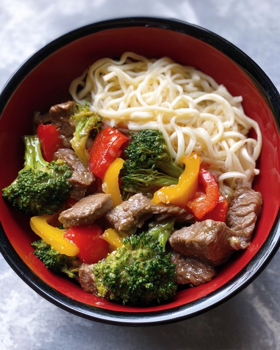 A white bowl filled with three main layers: soft white noodles on the right side, tender brown slices of beef mixed with bright green broccolini and vibrant pieces of red and yellow bell peppers on the left side, all lightly coated in a glossy sauce. The background has a white marbled texture, adding a clean and fresh look to the image. Photo taken with an iphone --ar 4:5 --v 7