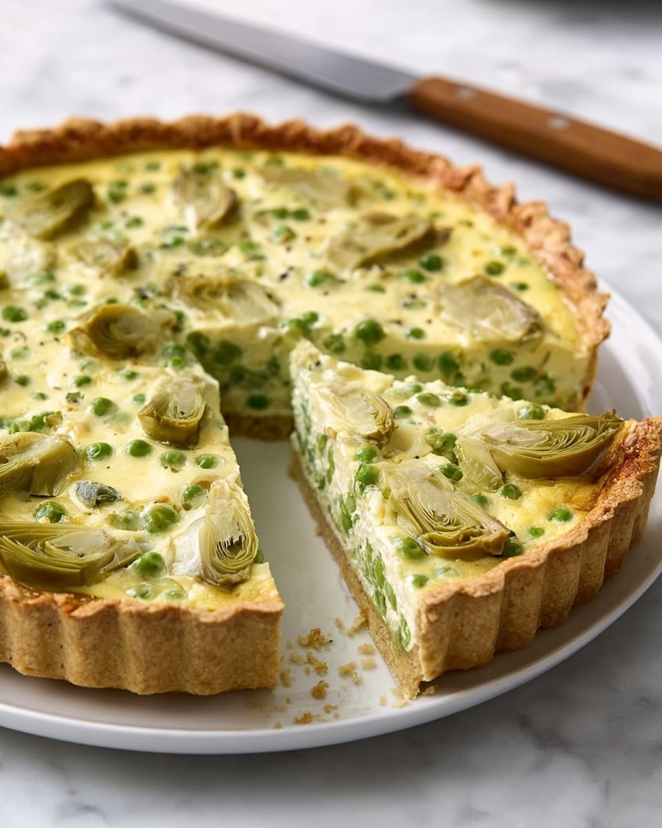 The image shows a round tart with a golden-brown, thick crust around the edges. Inside, there are two main layers: the bottom layer is a light green mix filled with small peas, and the top layer is a creamy, pale yellow-green custard with artichoke hearts cut in half scattered evenly on the surface. One slice is cut and slightly pulled out, revealing the inside layers clearly. The tart is placed on a white plate, set on a white marbled surface, with a wooden-handled knife next to it. photo taken with an iphone --ar 4:5 --v 7