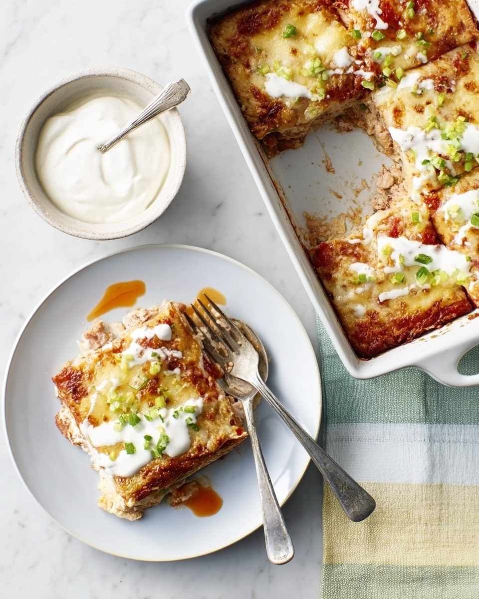 The image shows two slices of a baked dish on a white plate, each slice having three visible layers: a light brown crust at the bottom, a middle layer of light-colored chicken or sauce, and a top layer of golden melted cheese with green pieces sprinkled on top. There is white cream and red sauce drizzled on the slices, adding texture and color contrast. A fork rests on one slice, partially digging into the dish. In the top right corner, a white rectangular baking dish contains the remaining baked dish with some slices missing, showing a similar layered texture. To the left, there is a white round plate with a small white bowl of white cream and a spoon on top, all placed on a white marbled surface. Photo taken with an iphone --ar 4:5 --v 7