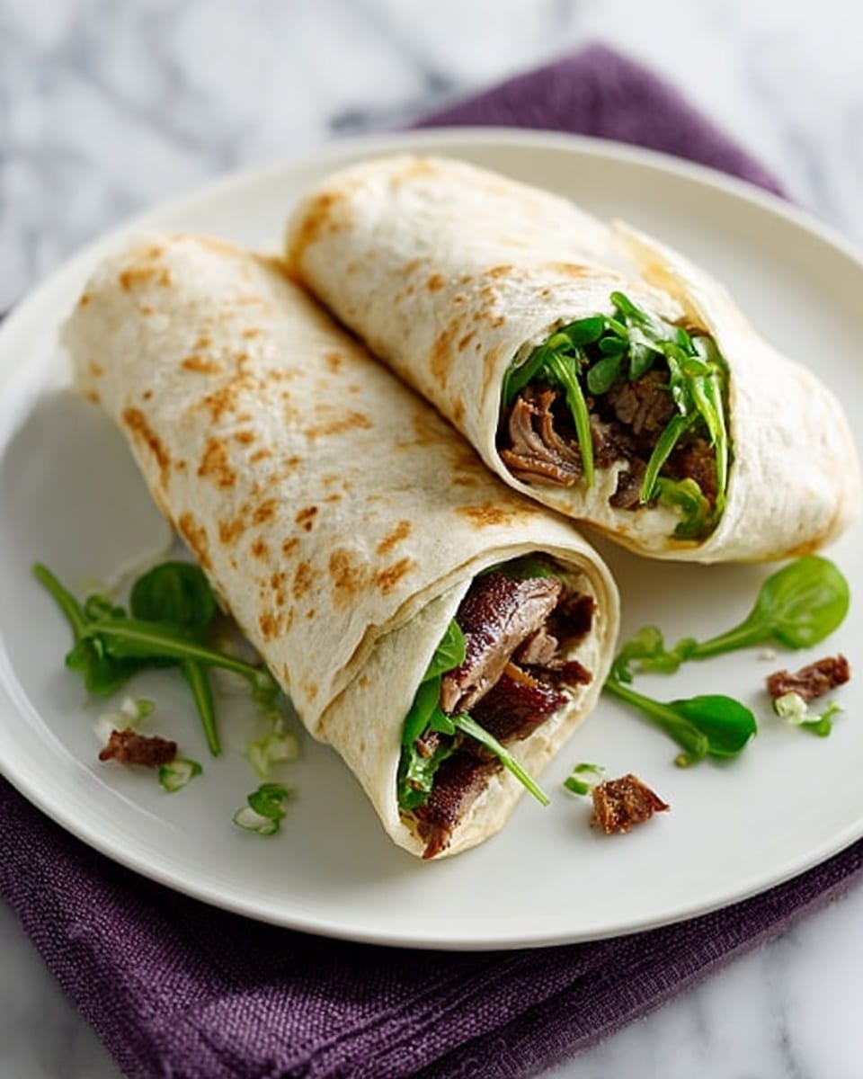 Two rolled wraps are placed on a white plate over a folded purple cloth. Each wrap has three visible layers: the outer layer is a light beige soft tortilla with some light brown spots, the middle layer contains pieces of cooked dark brown meat, and the inner layer shows fresh green leafy vegetables. Small green leaves and tiny brown meat pieces are scattered around the plate. The plate is set on a surface with a white marbled texture. photo taken with an iphone --ar 4:5 --v 7