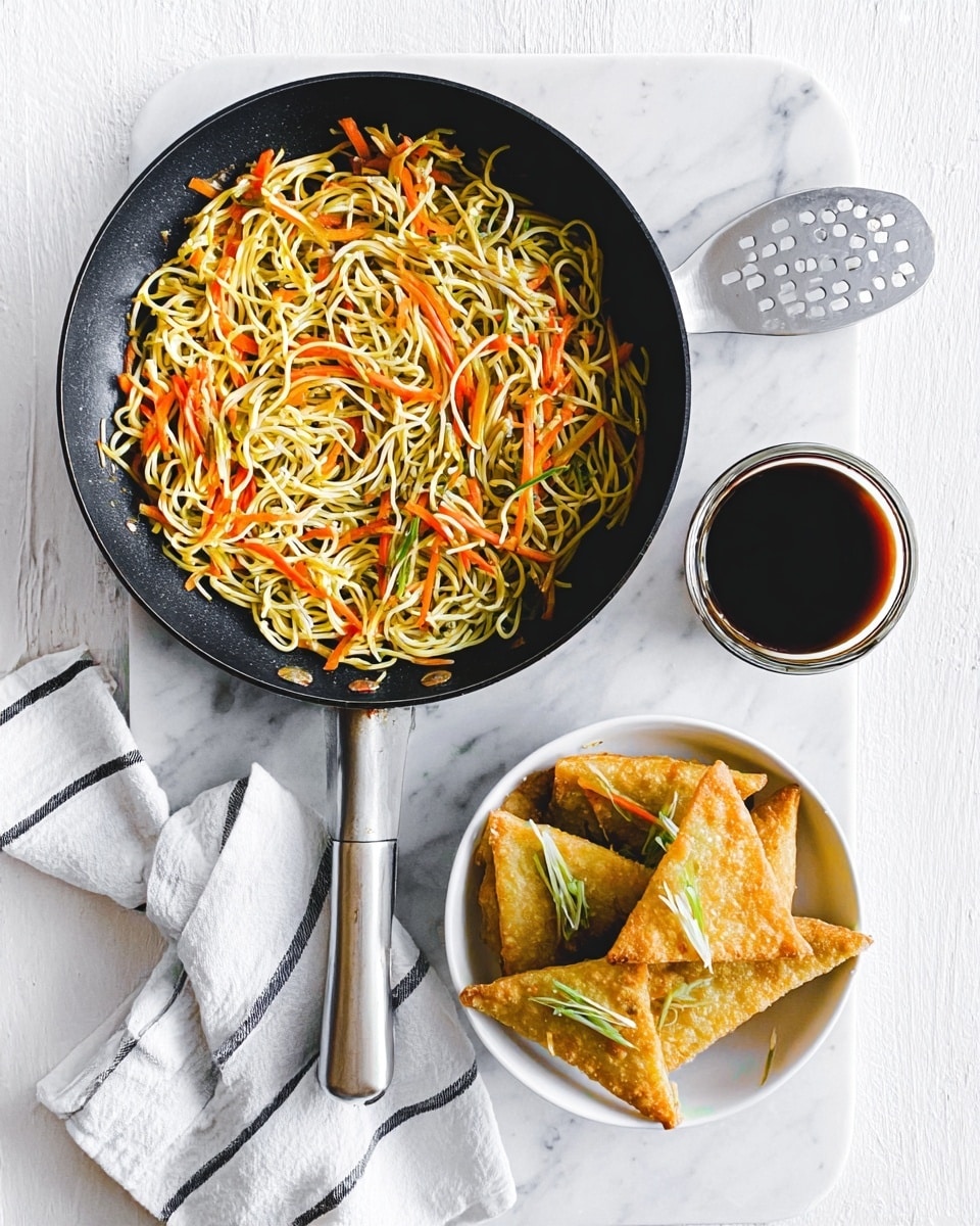 The image shows a black frying pan with two layers of food: the bottom layer is light yellow noodles, and on top are thin carrot and green vegetable strips mixed in, all placed on a white marbled surface. Next to the pan is a small white bowl filled with golden crispy fried tofu triangles, some topped with thin green garnishes. To the right of the bowl is a small clear glass bowl filled with dark soy sauce. Below the pan, on the white marbled surface, there is a white cloth with thin black stripes and a metallic slotted spatula resting on it. The photo taken with an iphone --ar 4:5 --v 7