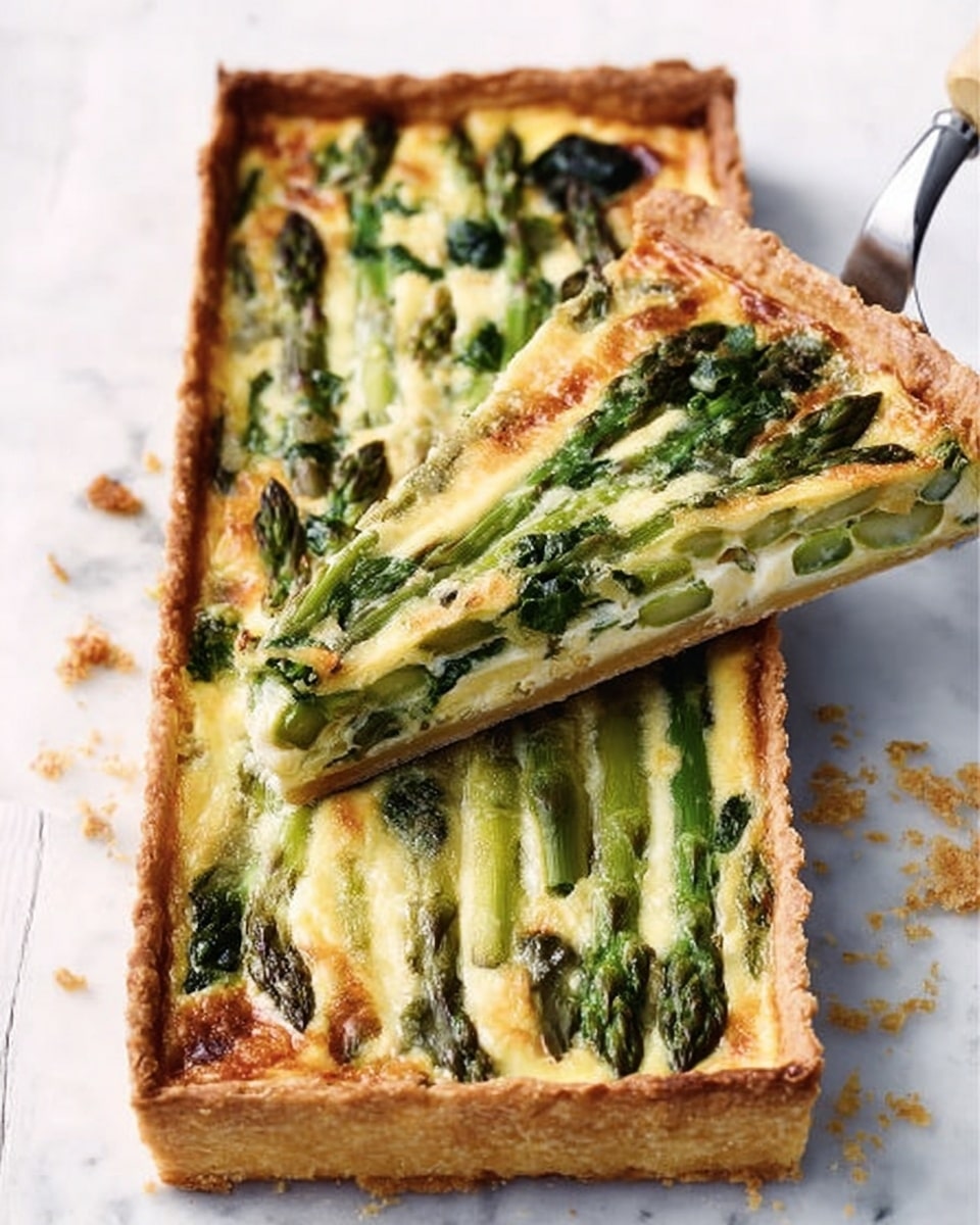 A rectangular tart with a golden, crisp crust holds a creamy filling layered with bright green asparagus tips and darker green leafy vegetables scattered throughout. The filling is smooth and pale yellow, with melted cheese lightly browned on top, giving a slightly bubbly texture. A silver spatula lifts a triangular slice, showing the even layers of crust and filling. The tart rests on a white marbled surface with a few small crumbs around it. Photo taken with an iphone --ar 4:5 --v 7