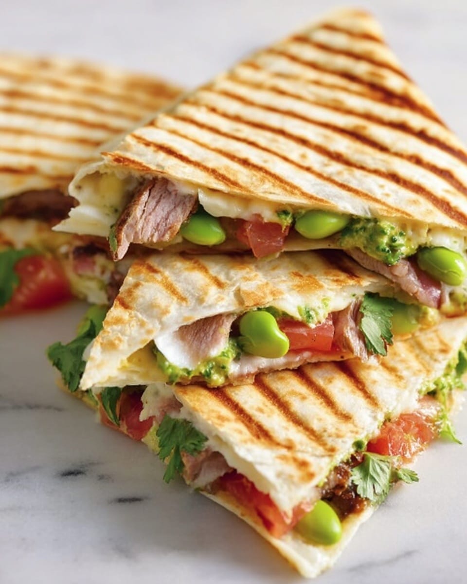 The image shows three triangular grilled quesadilla pieces stacked on a white marbled surface. Each piece has a golden-brown grilled pattern on the tortilla. The filling includes layers of light green edamame beans, vibrant red tomato chunks, melted creamy white cheese, fresh green cilantro leaves, and slices of cooked meat with a slightly pink center. The layers peek out from the open side, showing a mix of colors and textures like soft cheese, tender meat, and fresh vegetables. Photo taken with an iphone --ar 4:5 --v 7