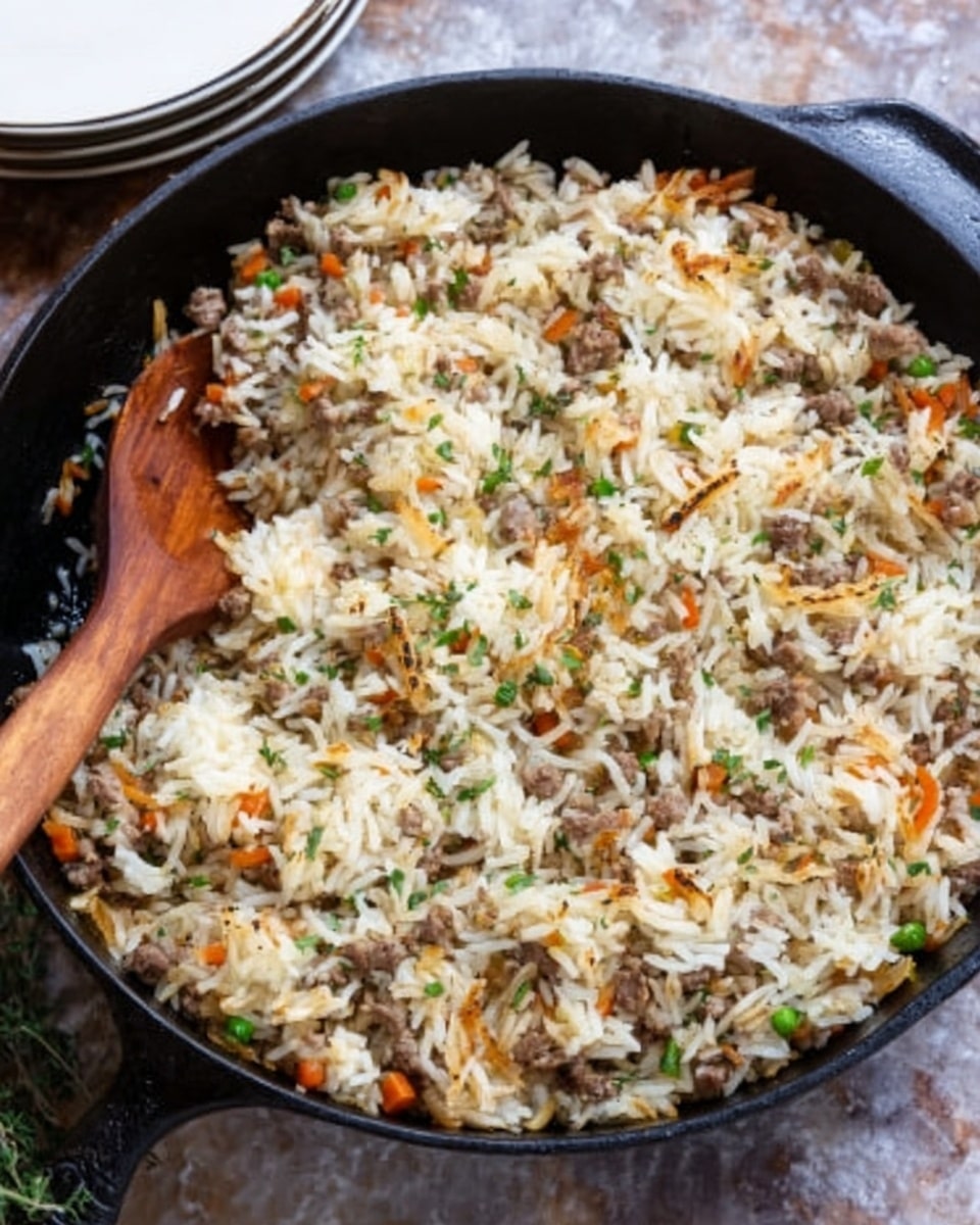 A black cast iron pan filled with a layered rice dish showing white and slightly browned grains on top. The mixture includes bits of cooked ground meat, small pieces of carrots, and finely chopped green herbs evenly spread throughout the dish. A wooden spoon is partially placed inside the pan on the left side, resting on the rice. The pan sits on a surface with a white marbled texture, and a partially visible stack of white plates is in the upper left background. photo taken with an iphone --ar 4:5 --v 7